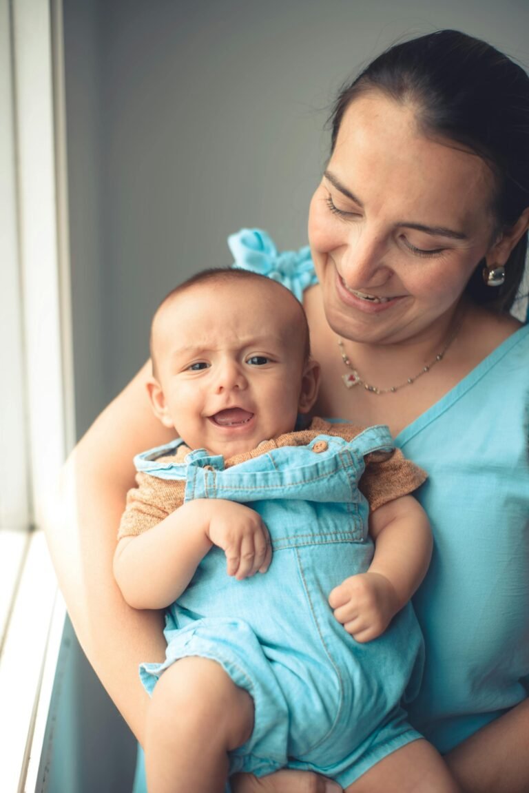 Mujer de celeste con bebe sonriendo